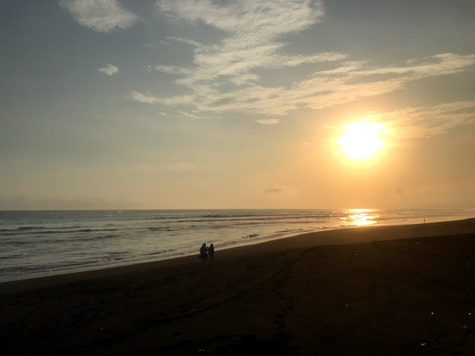 Panorama Pantai Wotgalih di Kecamatan Yosowilangun, Lumajang, menawarkan hamparan pasir hitam eksotis dengan jembatan bambu ikonik yang menjadi spot favorit wisatawan.